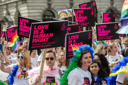 A protest of people for LGBTQ+  holding Love is a human right banners